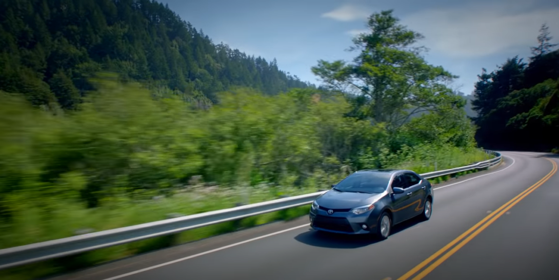 Fast-moving sedan on a downhill highway