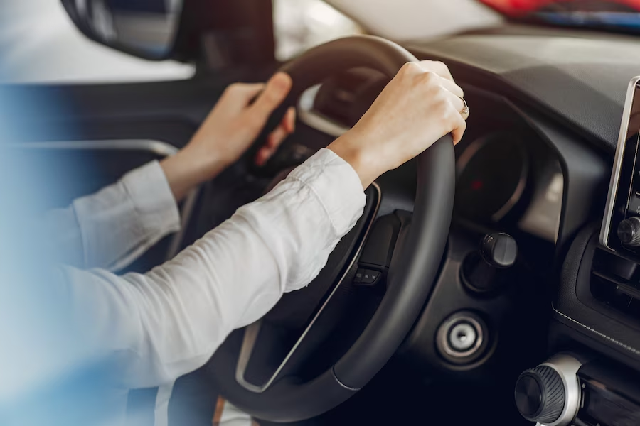 Hands on a car steering wheel