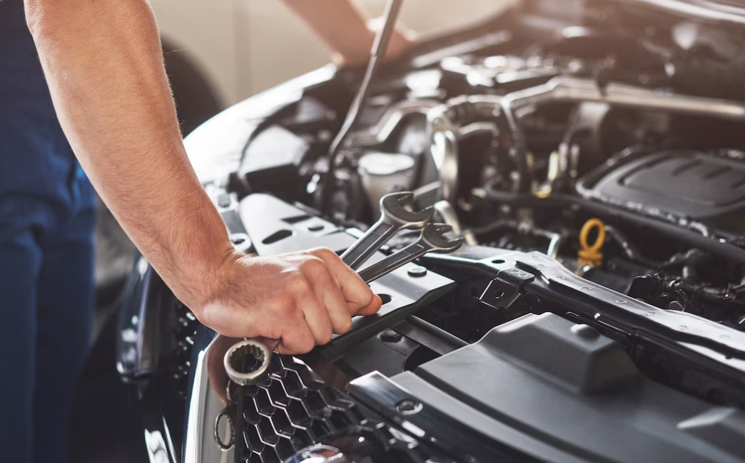 hand holds the key for repairing the and opened car cockpit