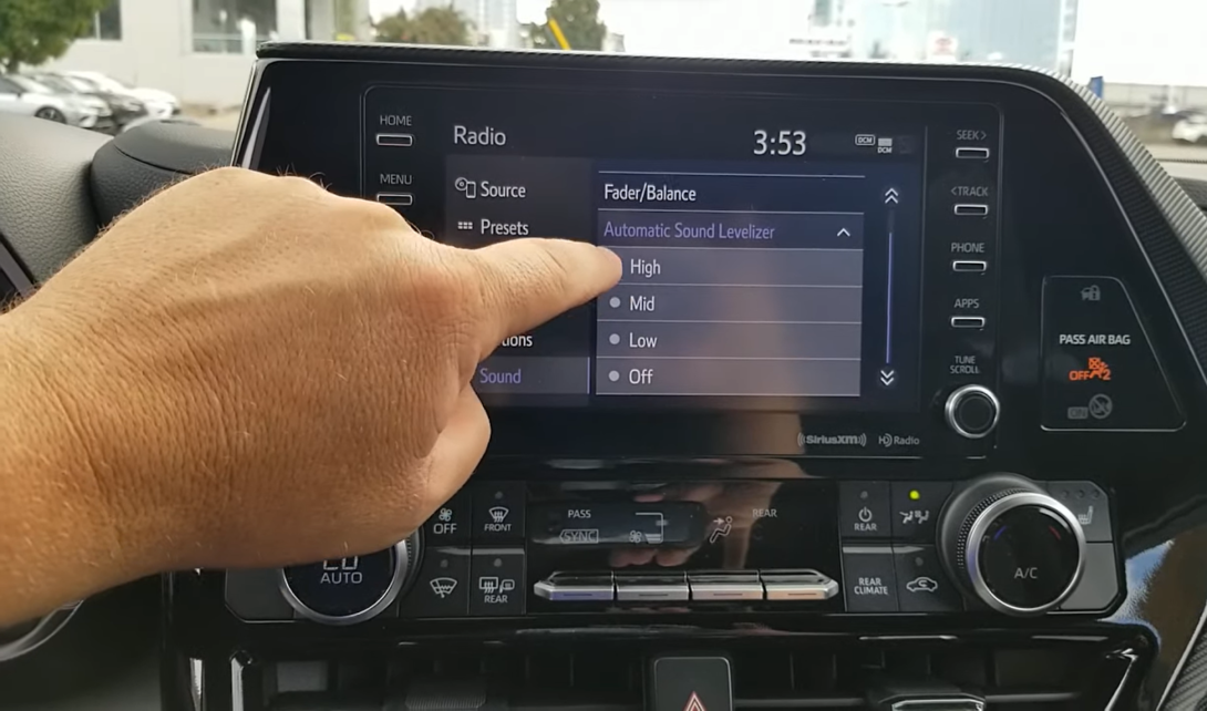 hand pointing out on the screen in the car - automatic sound levelizer 